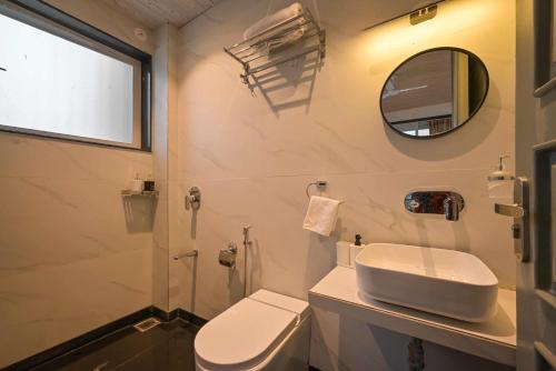罗纳瓦拉Elegant Villa By Tropicana Stays的一间带卫生间、水槽和镜子的浴室