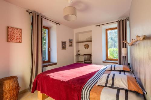 圣若里奥Appartement la tournette的一间卧室配有一张带红色毯子的床