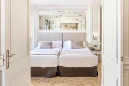 马德里VP Jardín de Recoletos的白色客房的两张床,设有窗户