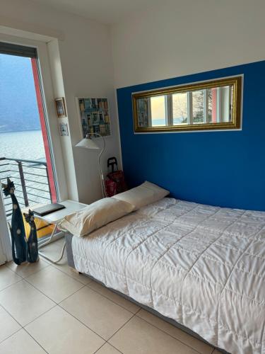 阿巴迪亚拉里亚纳a...fior di lago的一间卧室设有一张床和蓝色的墙壁
