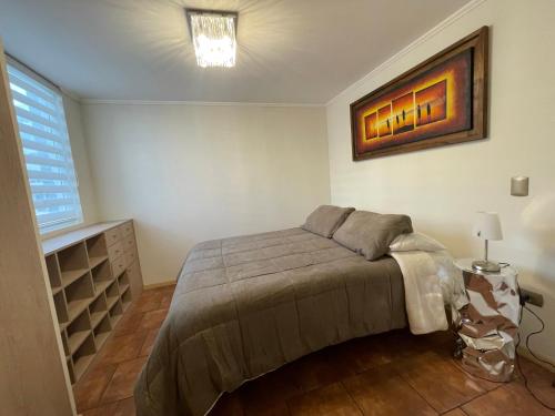 库里科Depto para 2 a 4 personas的卧室配有一张床,墙上挂有绘画作品