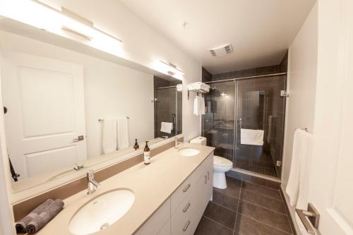 坎布里奇The Laundry Rooms Gaslight Cambridge的白色的浴室设有2个盥洗盆和淋浴。