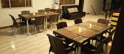 马尼萨莱斯Hotel Palo Grande的餐厅设有桌椅和蜡烛