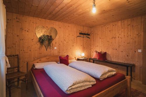 丰塔内拉Chalet Frederik的卧室配有木墙内的两张床