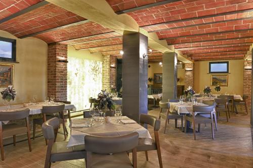 佩乔利区Agriturismo Pelagaccio的一间在房间内配有桌椅的餐厅