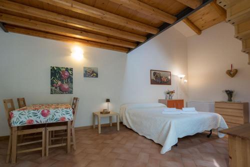 维罗纳皮纳托农家乐的一间卧室配有两张床和一张桌子及椅子