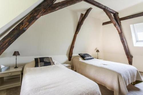 勒比格Au bord de la Vézère的木梁客房的两张床