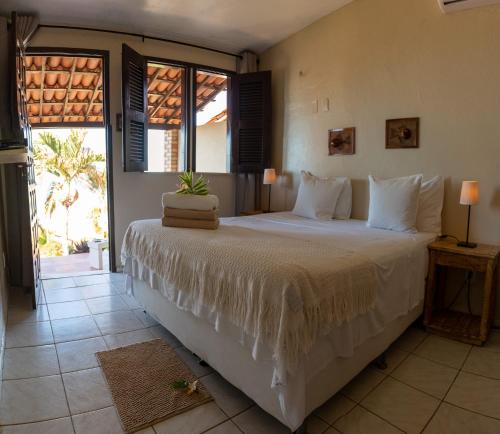 卡诺格布拉达Pousada Vila Canoa的一间卧室设有一张大床和大窗户