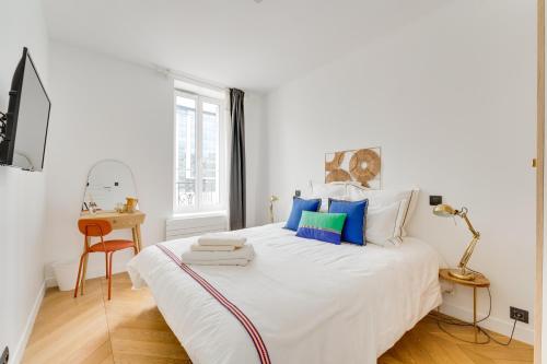 塞纳河畔讷伊PorteMaillot & La Défense 4 Bedroom 10 people的白色卧室配有一张带蓝色枕头的大床