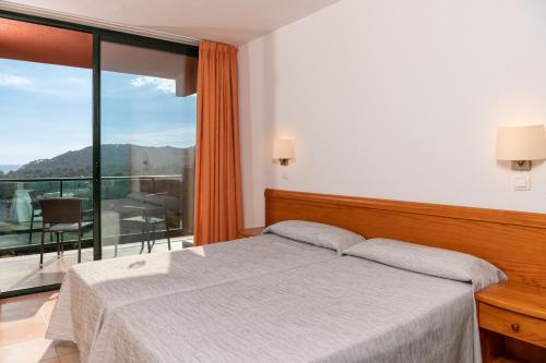 罗列特海岸阿尔巴玛公寓酒店的一间卧室设有一张床和一个大窗户