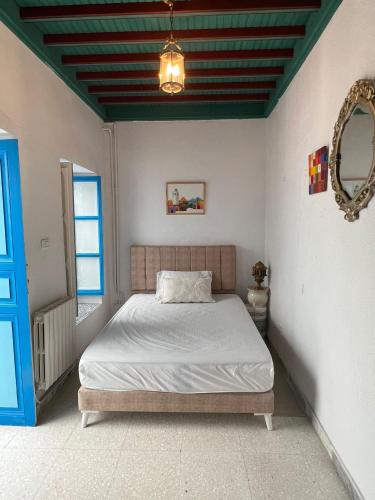 西迪·布·赛义德La maison 4 puits的一间卧室配有一张床和一个蓝色的门
