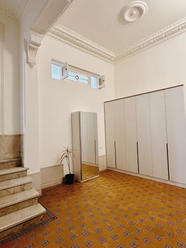 蒙得维的亚Rococo Apart的一间空房间,有白色的橱柜和楼梯