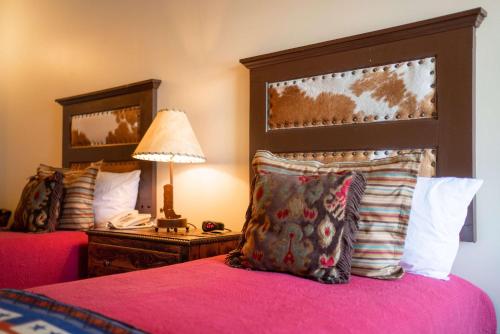 谢里登Sheridan Inn - Best Western Signature Collection的一间卧室配有两张床、一盏灯和一部电话