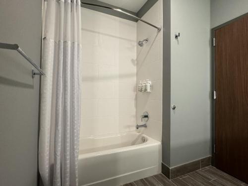劳雷尔山La Quinta Inn & Suites by Wyndham Mount Laurel Moorestown的浴室配有白色的浴缸和淋浴帘