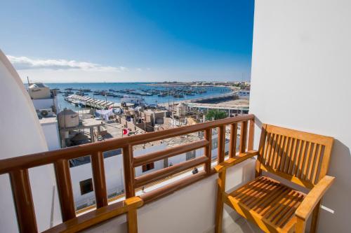 帕拉卡斯Hotel Riviera Inka Paracas的木凳坐在俯瞰着海港的阳台