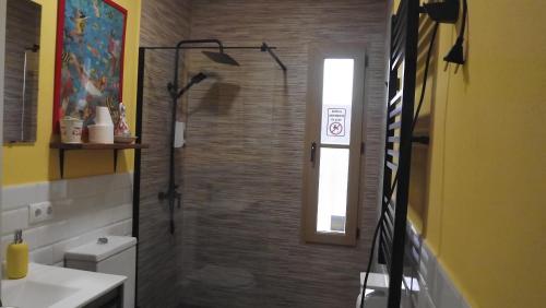 埃尔卡斯蒂略德拉斯瓜尔达斯Villa Saudade, casa entre encinas的带淋浴、卫生间和窗户的浴室