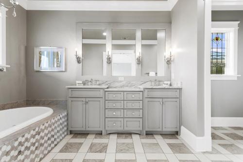 德斯坦Melrose Place的浴室设有2个水槽、浴缸和镜子