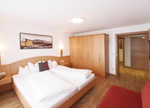 安纳贝格-伦格茨乌特施拉格阿尔卑斯公寓的卧室配有白色的床和橱柜。