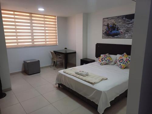 圣希尔Aptahotel Guest House的一间卧室配有一张床、一张桌子和一个窗户。