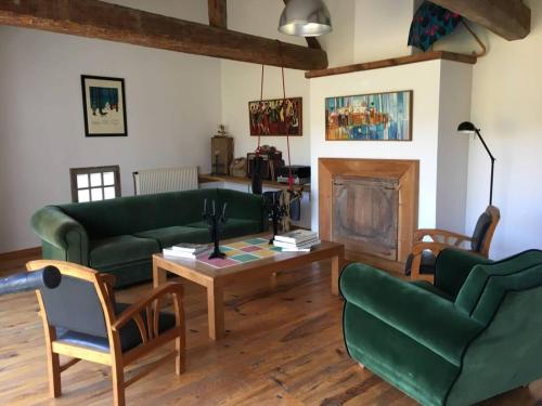 圣阿姆贝尔维尤Lumineuse Et Spacieuse Maison Style Loft的客厅配有两张绿色沙发和一张咖啡桌