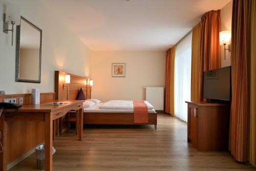 拉廷根克鲁蒙维格庄园酒店的配有一张床和一张书桌的酒店客房