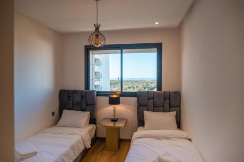 拉巴特Appartement luxueux Prestigia的带窗户的客房内的两张床