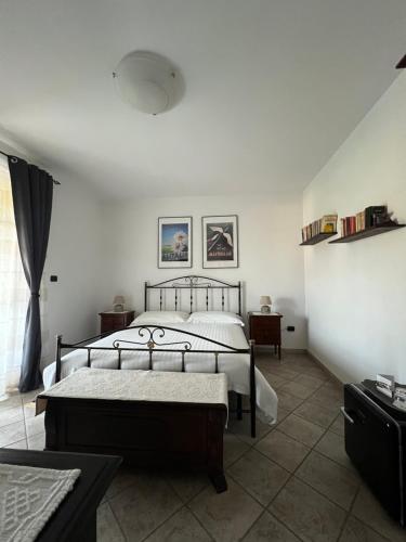 蒙卡尔沃Cascina il Volo的一间卧室设有两张床、两张桌子和窗户。