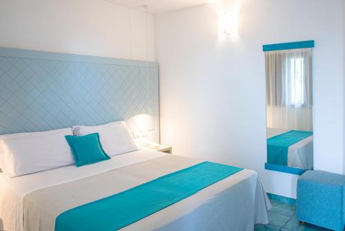 滨海波利尼亚诺皮埃特拉布鲁Spa度假酒店 - CDS酒店的一间卧室配有一张大床和蓝色床头板