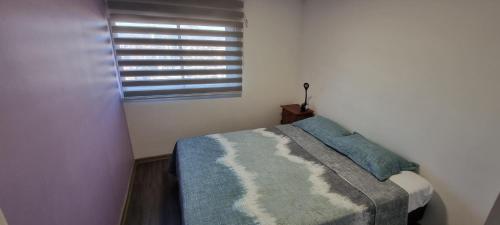 圣地亚哥Hermoso y acogedor Apartamento的一间小卧室,配有一张带窗户的床