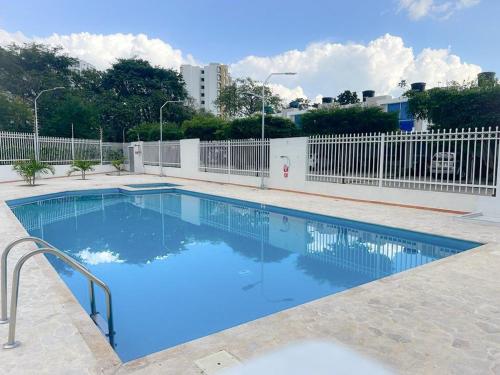 巴耶杜帕尔Apartaestudio Amoblado的蓝色的游泳池,设有白色的围栏