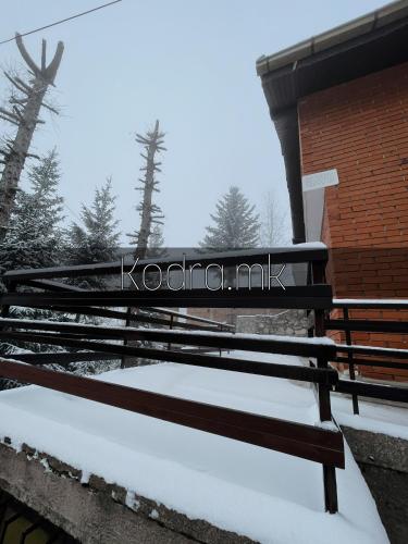 泰托沃Kodra - Villa 71的大楼旁边的雪地里遮着长凳