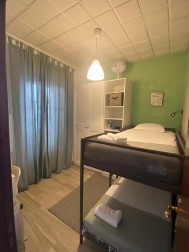 里斯本Beato Typical House的一间卧室设有一张双层床和绿色的墙壁