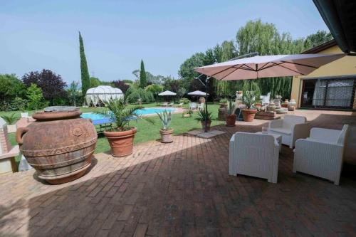 比萨Villa Fiore Luxury Pool & Garden的一个带椅子和遮阳伞的庭院和一个游泳池