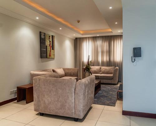 东勒贡Unit 14, Capella Place的客厅配有两张沙发和一台电视机