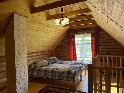 拉希夫ШОВКОВА КОСИЦЯ的小木屋内一间卧室,配有一张床