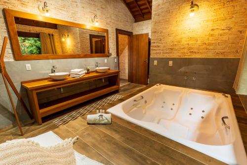 蒙特韦尔迪Pousada Boutique Vilage de Minas的带浴缸和盥洗盆的大浴室