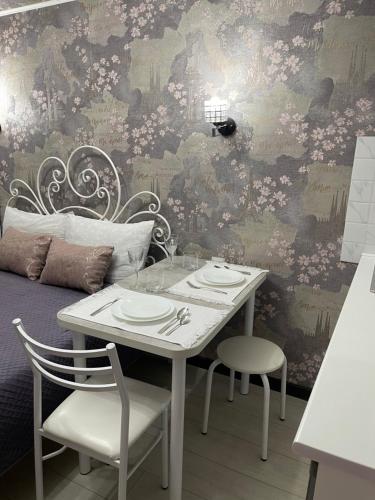 比什凯克Уютная комната-студия в центре Бишкека的餐桌、两把椅子和鲜花墙