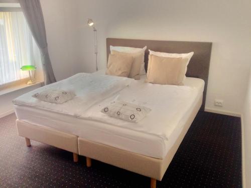 Freiroda莱比锡机场旅馆的一张配有白色床单和枕头的大床