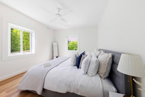 悉尼Little Manly 3 Bedroom Sanctuary的白色卧室配有一张带蓝色枕头的大床