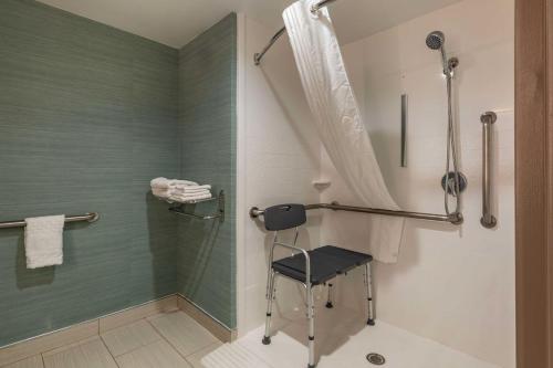 沃本新英格兰贝斯特韦斯特酒店 - 波士顿/北部酒店的带淋浴的浴室和椅子