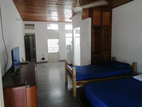 拉多拉达Casa lowcost relajación的客房设有两张床、一张桌子和一台电视机。