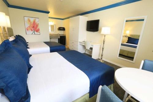 奥兰多Orlando International Drive North Hotel的酒店客房设有两张床和一张桌子。