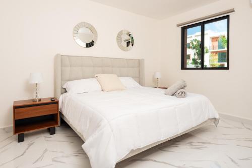 坎昆2BR Moderno en residencial Ombu的白色卧室配有一张大床和一张桌子