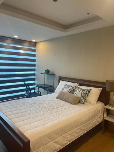 马尼拉BSA TWIN TOWER的一间卧室设有一张大床和窗户