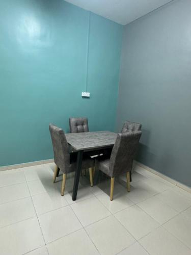 昔加末S&S Homestay Segamat的蓝色墙壁的房间里一张桌子和椅子