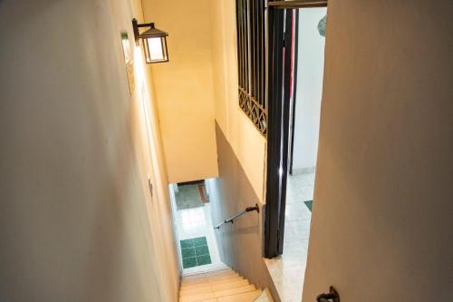 伊瓦格Coliving7 Aparta Hotel & Habitaciones的走廊上设有楼梯,上面有灯