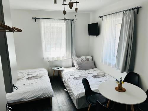 洛克特Apartmány u Kuželky的客房设有两张床、一张桌子和一张桌子以及椅子。