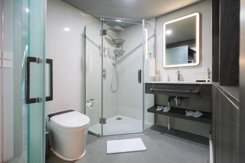 坎古Aster Apartment Bali的带淋浴、卫生间和盥洗盆的浴室