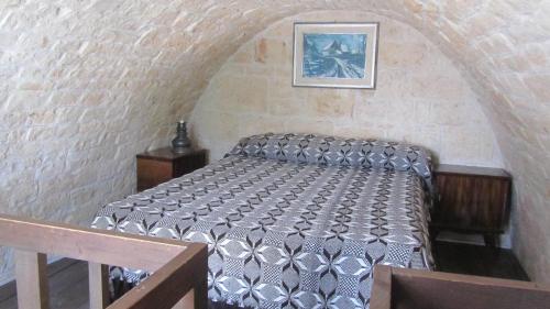 阿尔贝罗贝洛Trullo Malvisco的卧室配有砖墙内的床铺