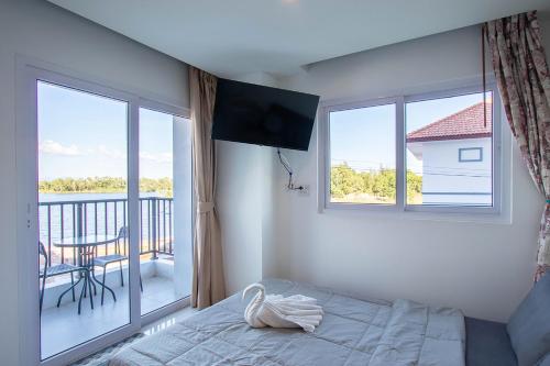 Ban Phlong SawaiMantra Beach condominium M116,M140的一间卧室设有一张床和一个阳台的窗户。